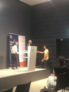 Student walking to stage to accept Best Presentation Award at a conference.