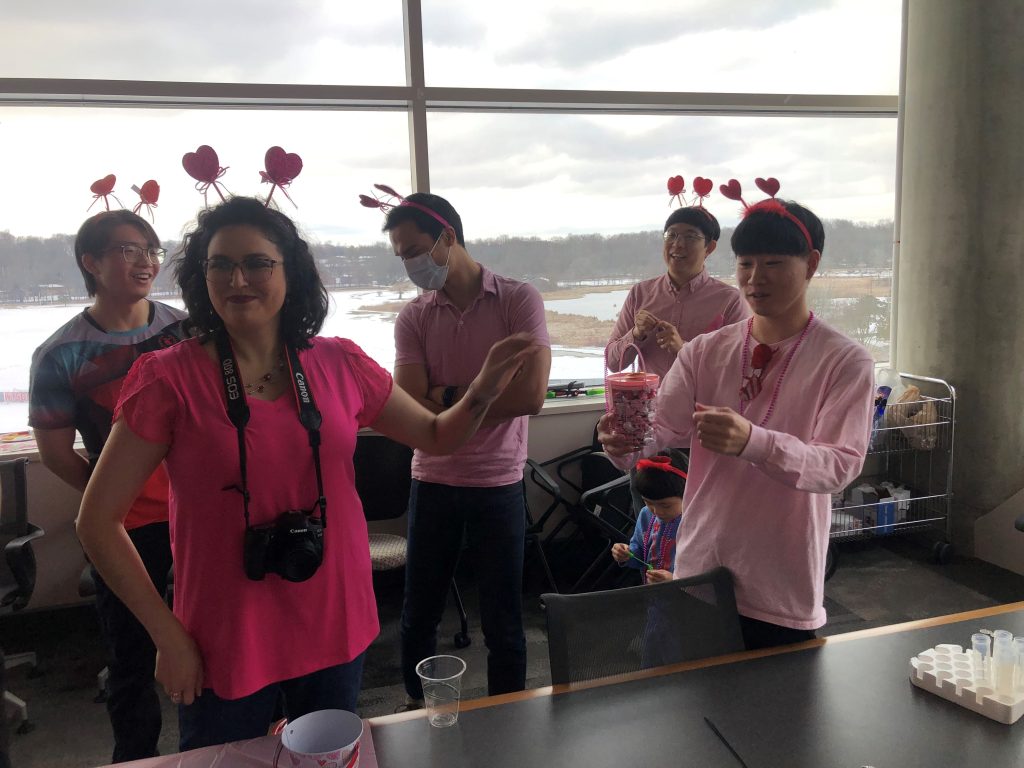Four people wearing pink shirts and heart headbands for a Valentine's Day party. 