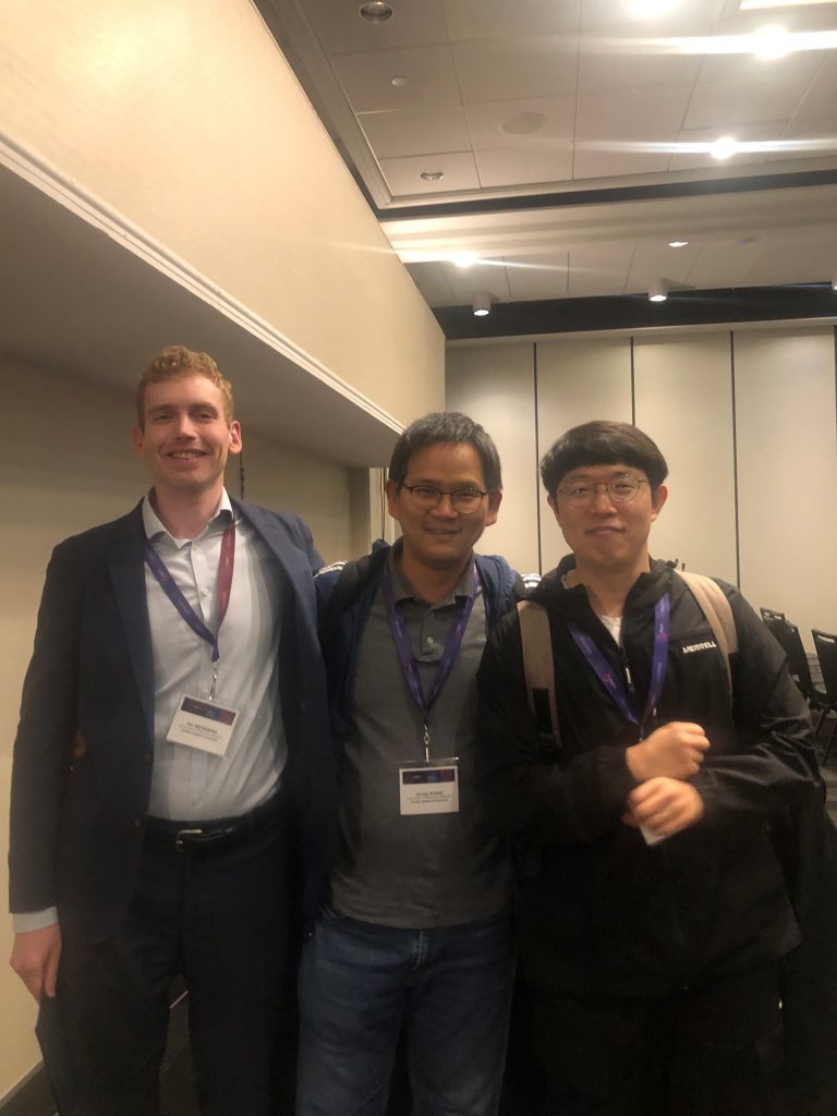 Professor (middle) with two students at a business event. 