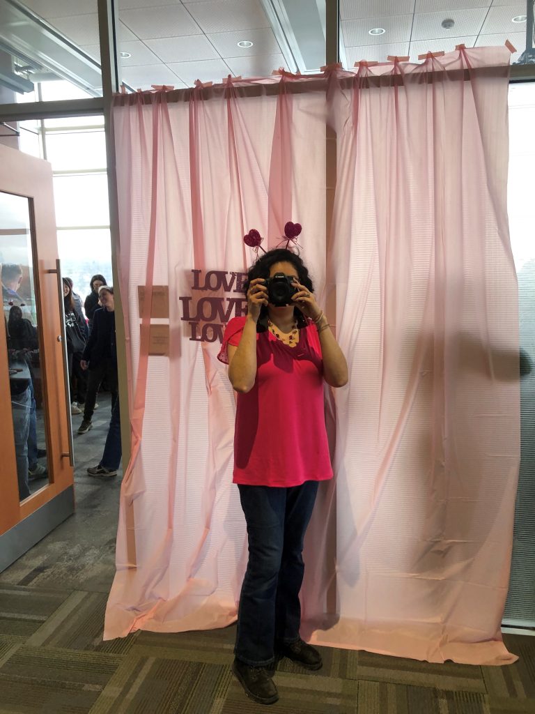 Person holding camera wearing a heart headband for a Valentine's Day party. 